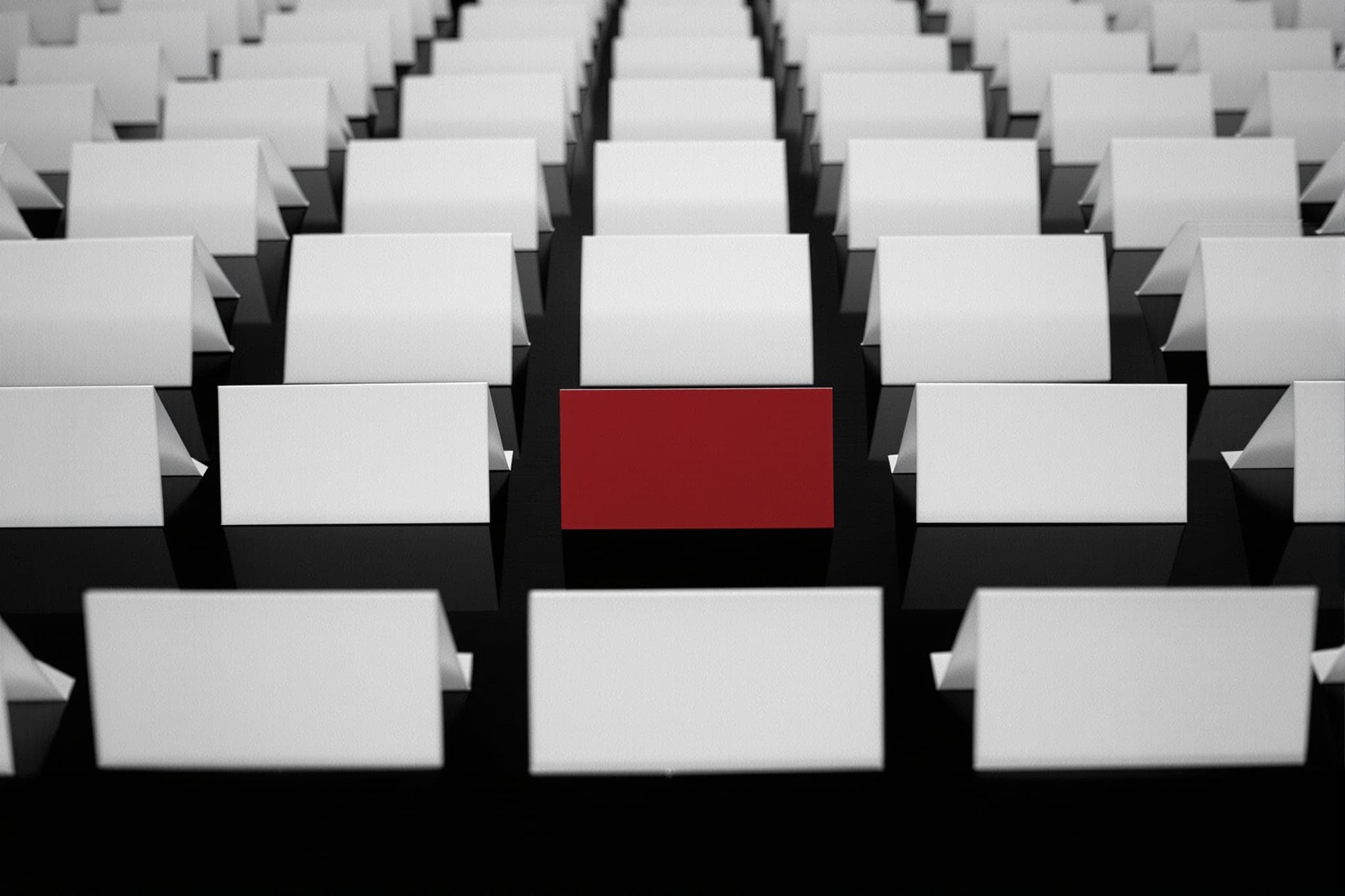 A long row of blank white place cards, exactly one of them crimson