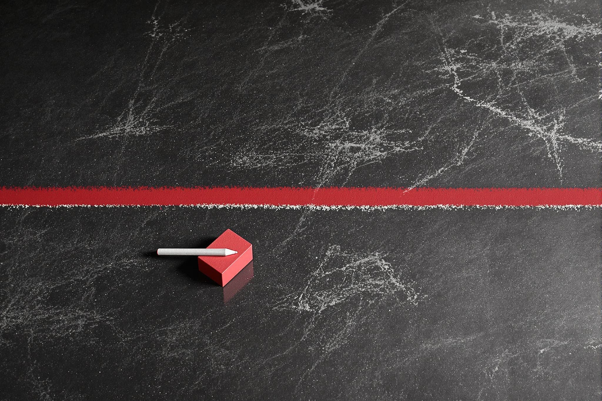 A single chalk line across a concrete floor, a crimson chalk block on one side