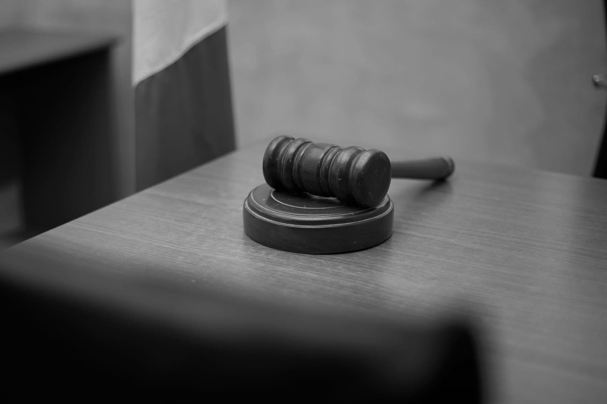 A wooden gavel resting on its block on a desk