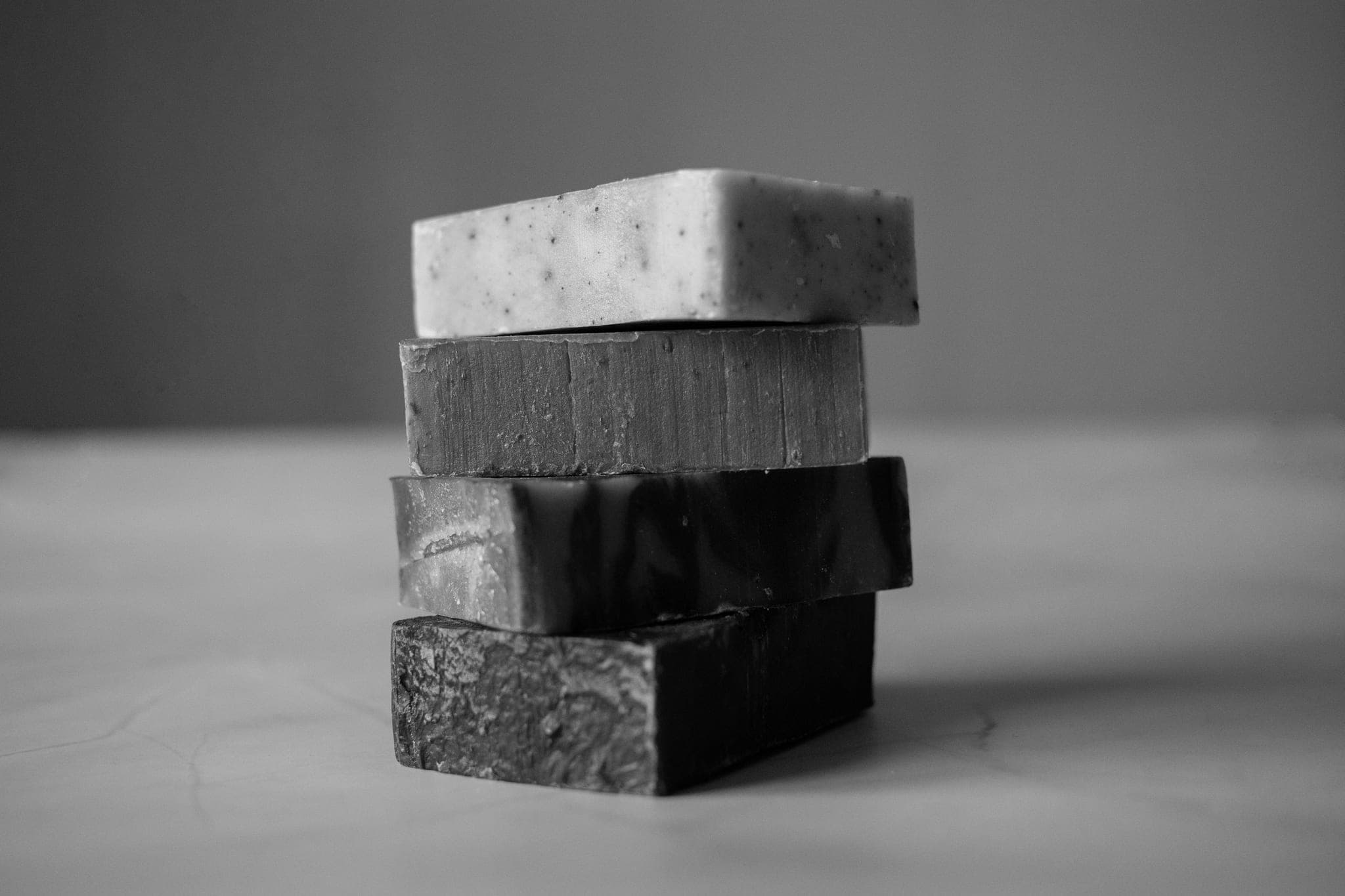 Four bars of soap stacked on a pale table