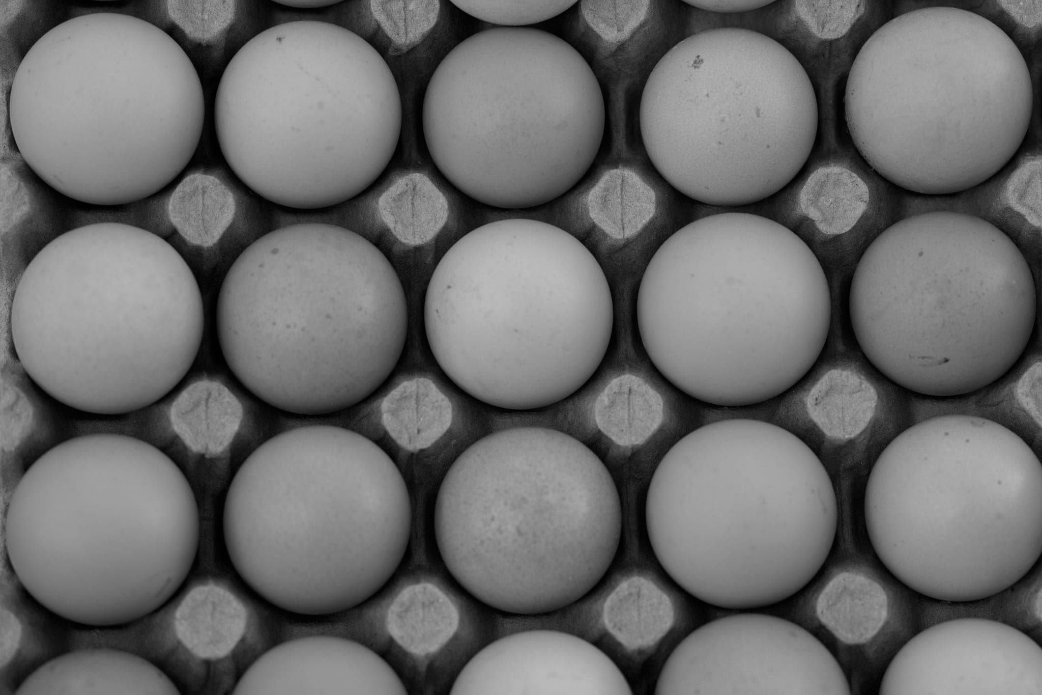 Brown eggs seen from above, filling a cardboard tray cell by cell