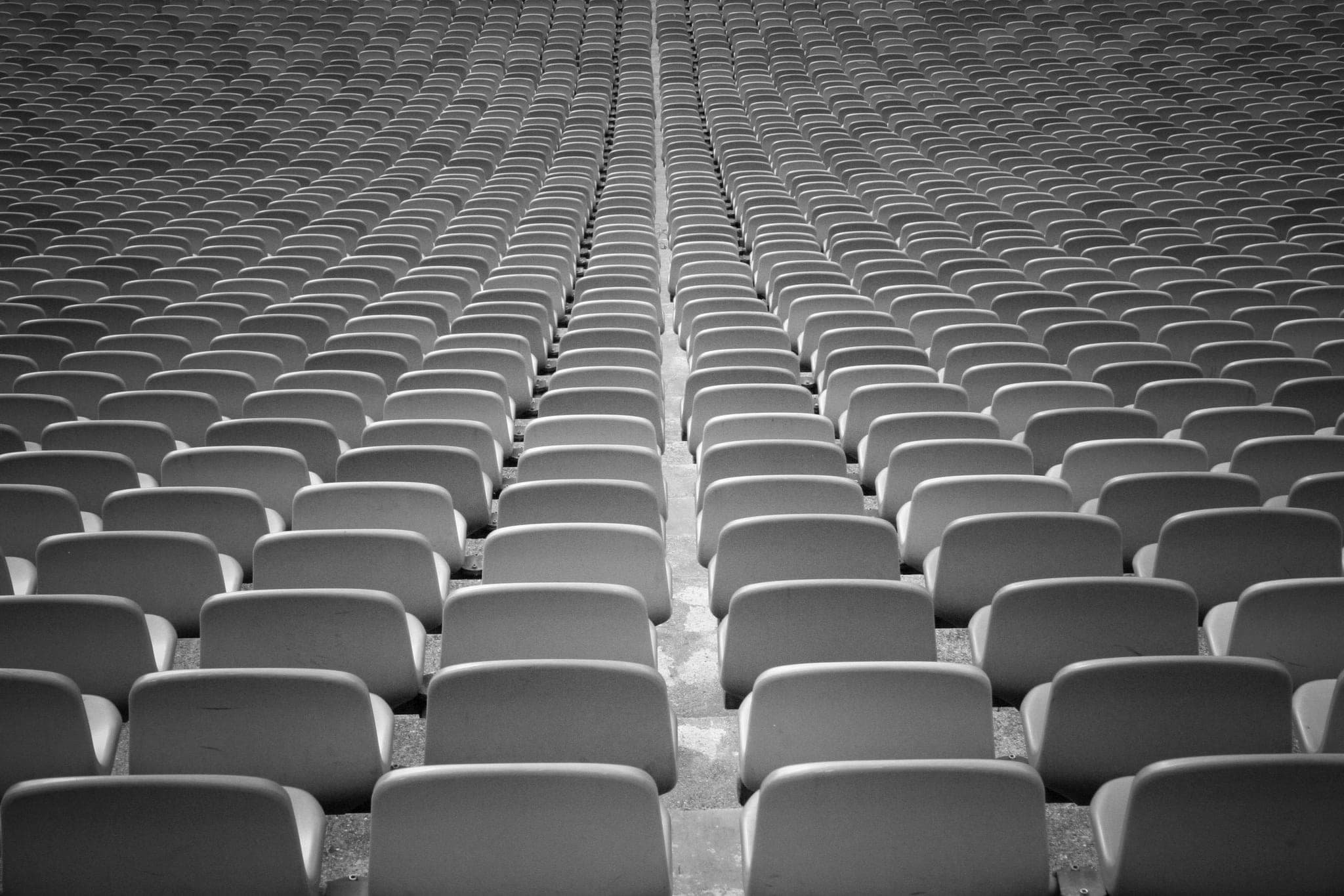 Tiers of empty seats rising away from the camera, split by a central aisle