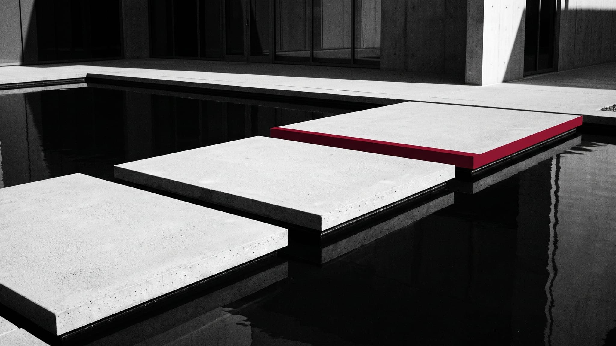 Three concrete pads across a reflecting pool, the furthest edged crimson