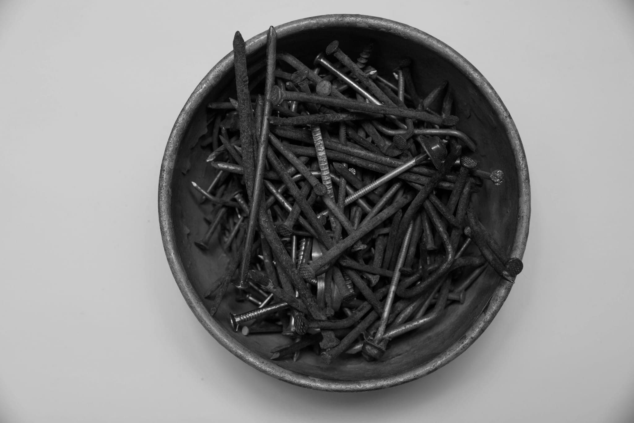 A metal bowl full of rusty nails, seen from above