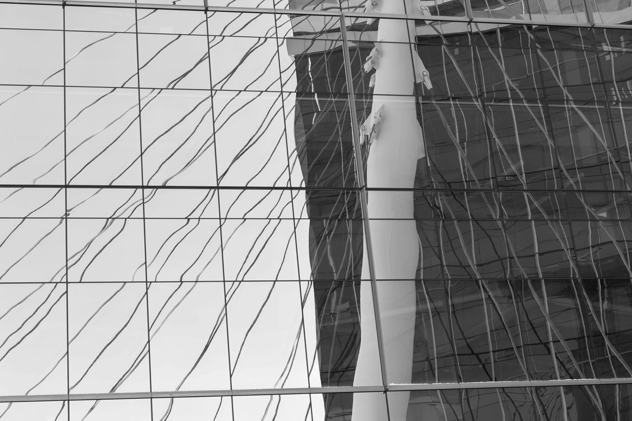 A glass facade reflecting the building opposite it