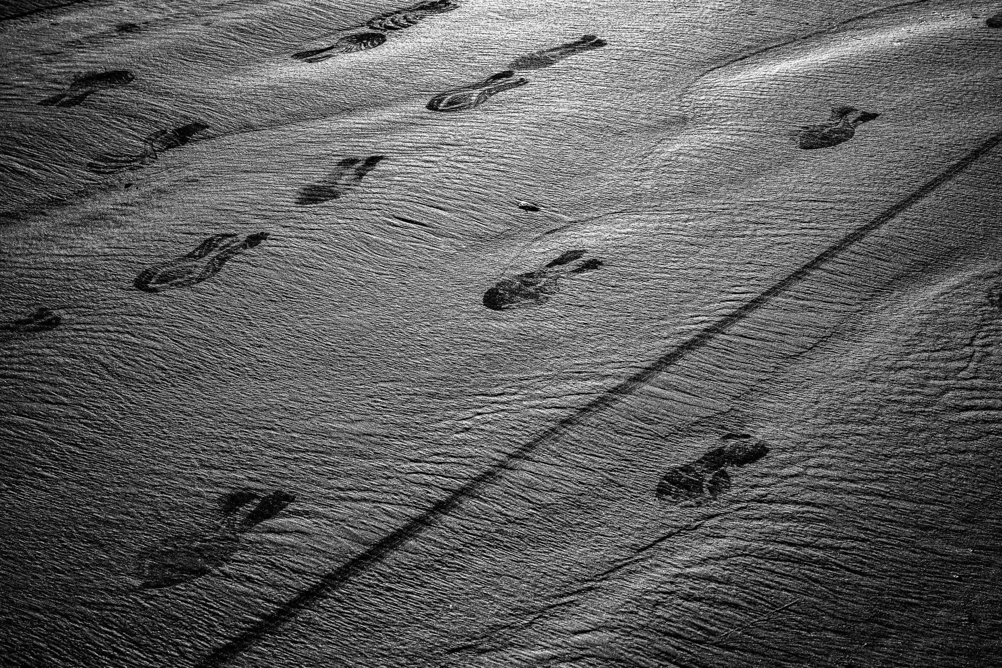 Footprints pressed into wet sand