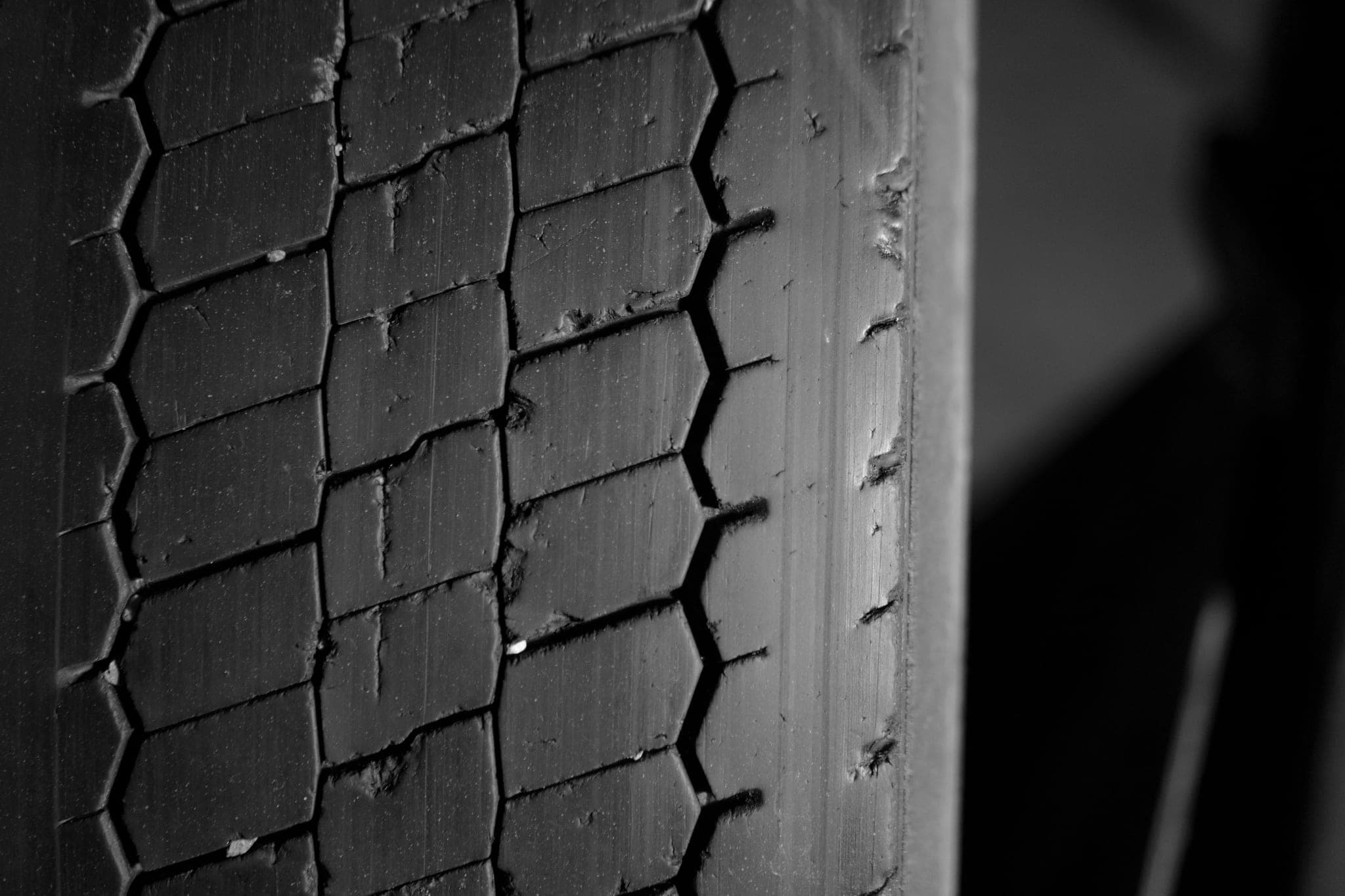 Close-up of a worn tyre tread, small stones caught in the grooves