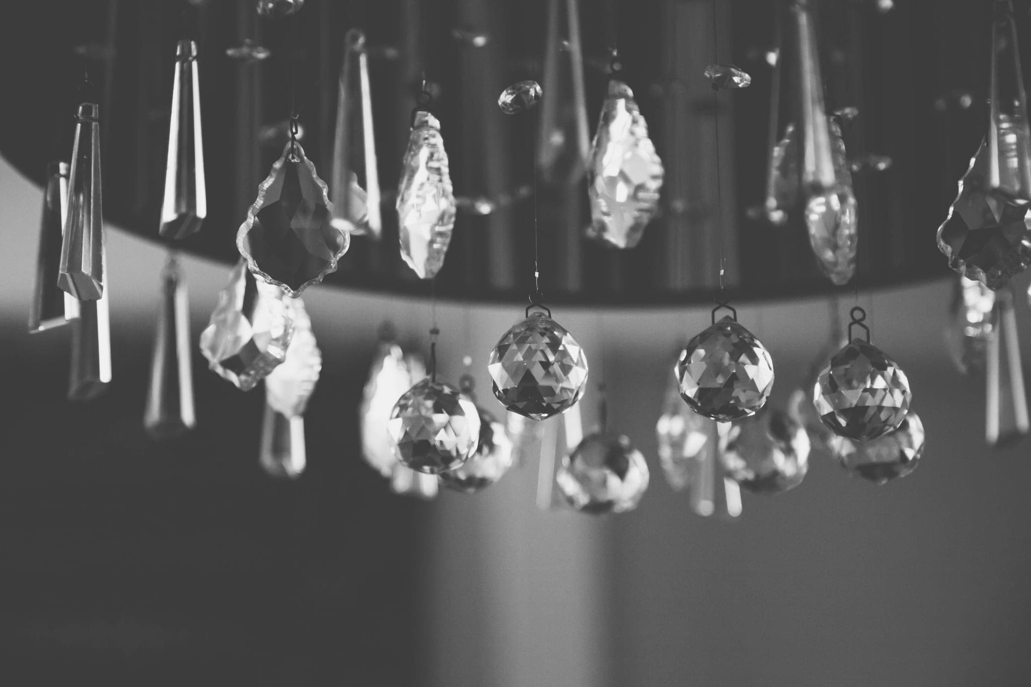 Faceted crystal pendants hanging beneath a chandelier