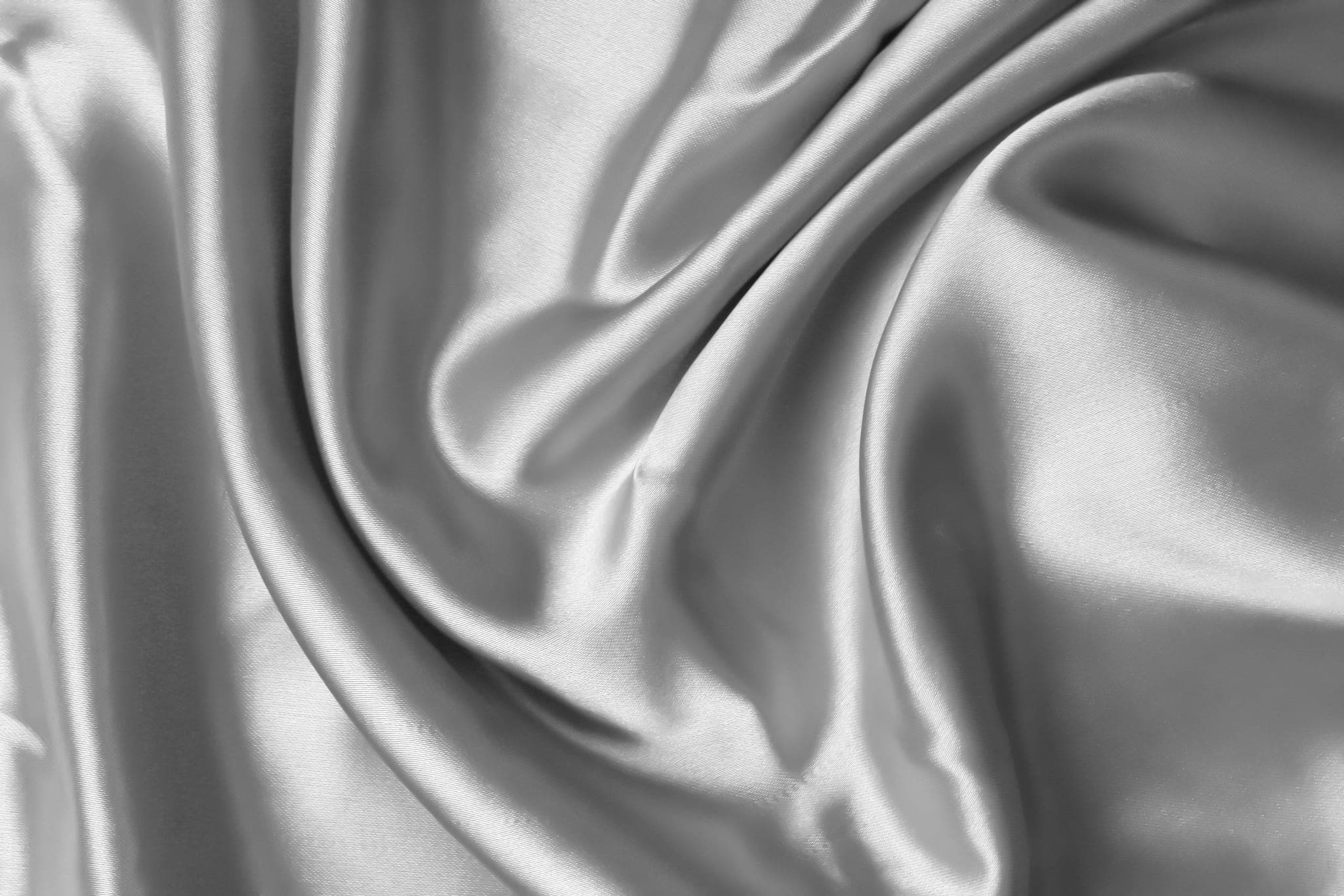 Folds of satin fabric swirling across the frame