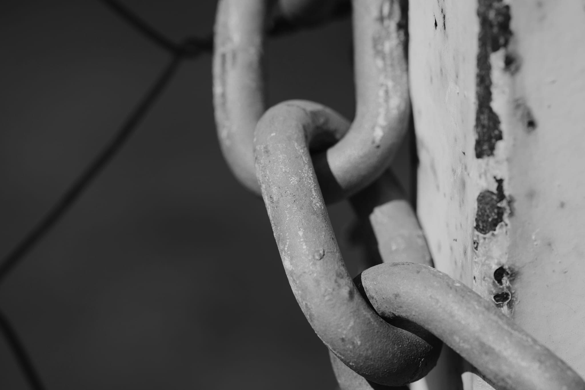 A rusted chain wrapped around a weathered post