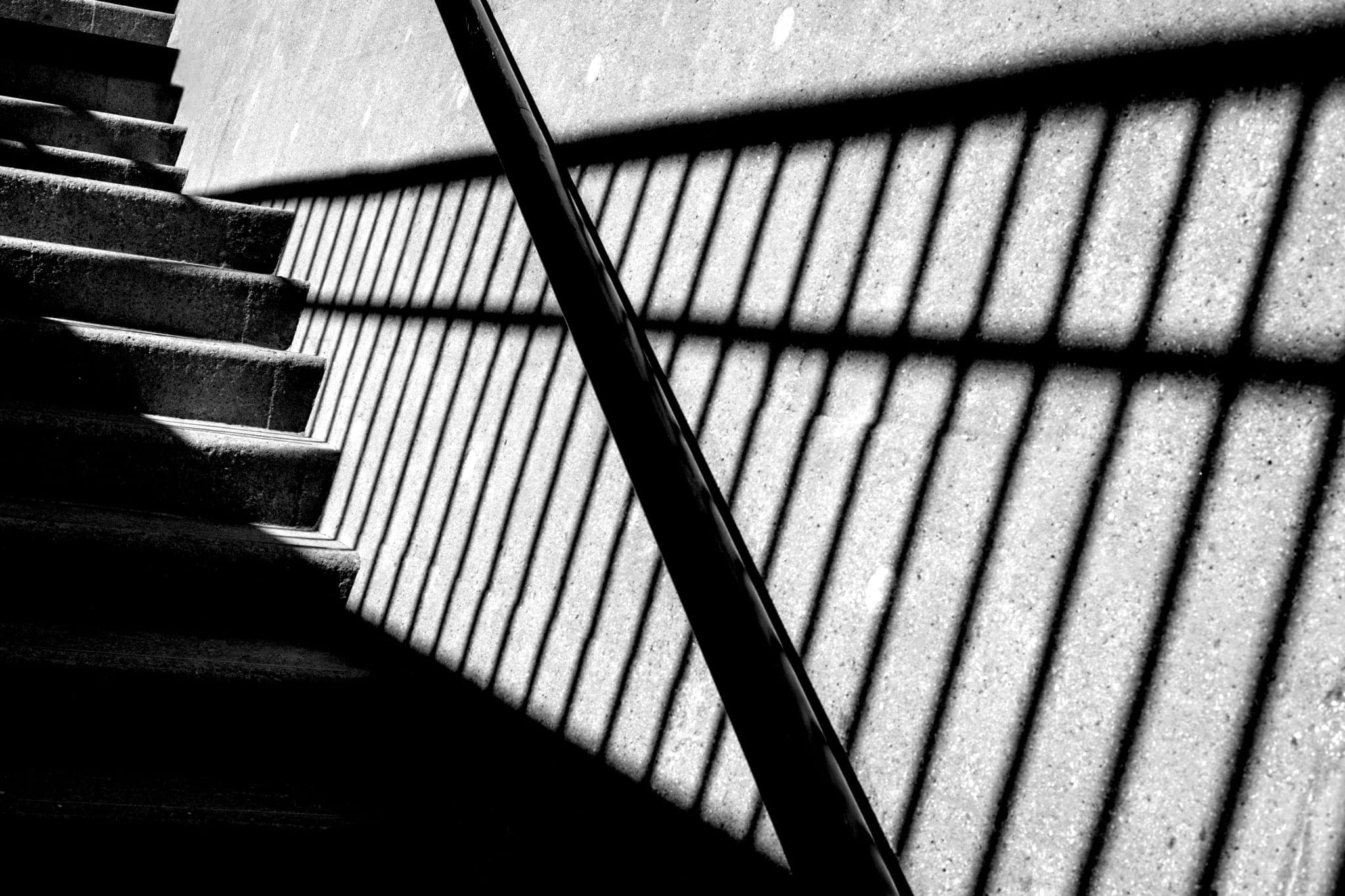 Shadows falling in geometric blocks across a stairwell