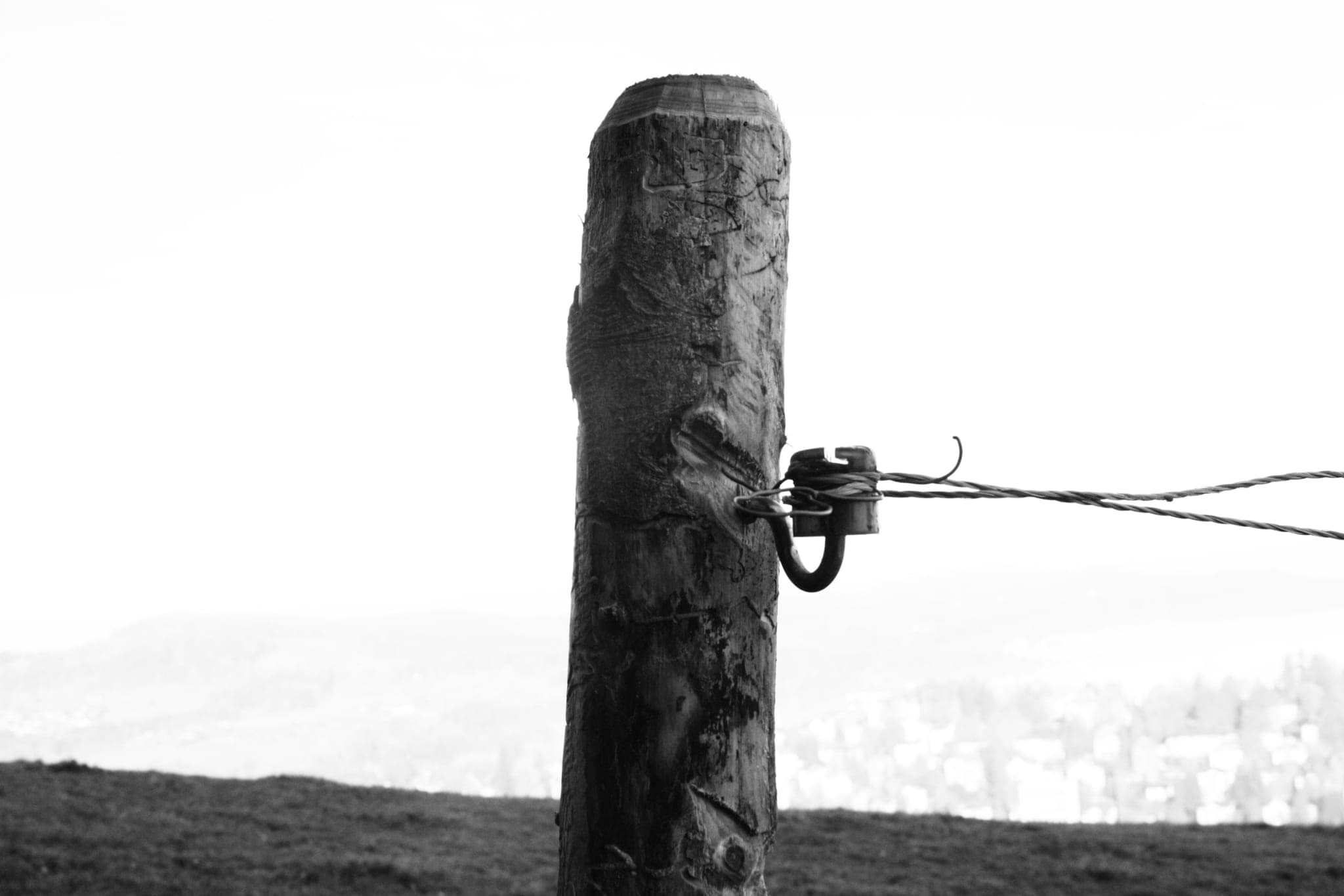 A wooden post and the wire of a fence