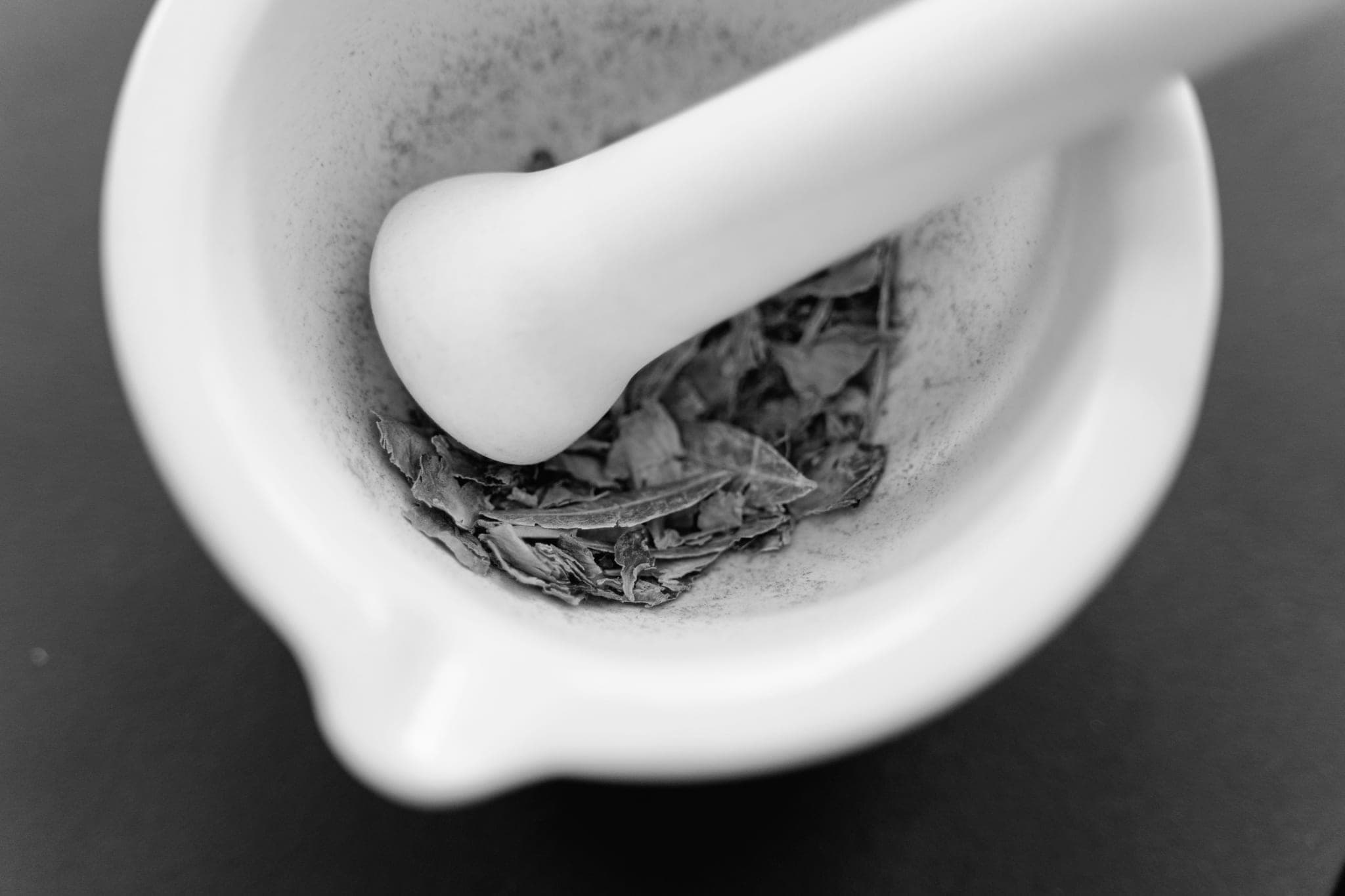 Chày và cối sứ trắng, đáy cối có ít lá khô