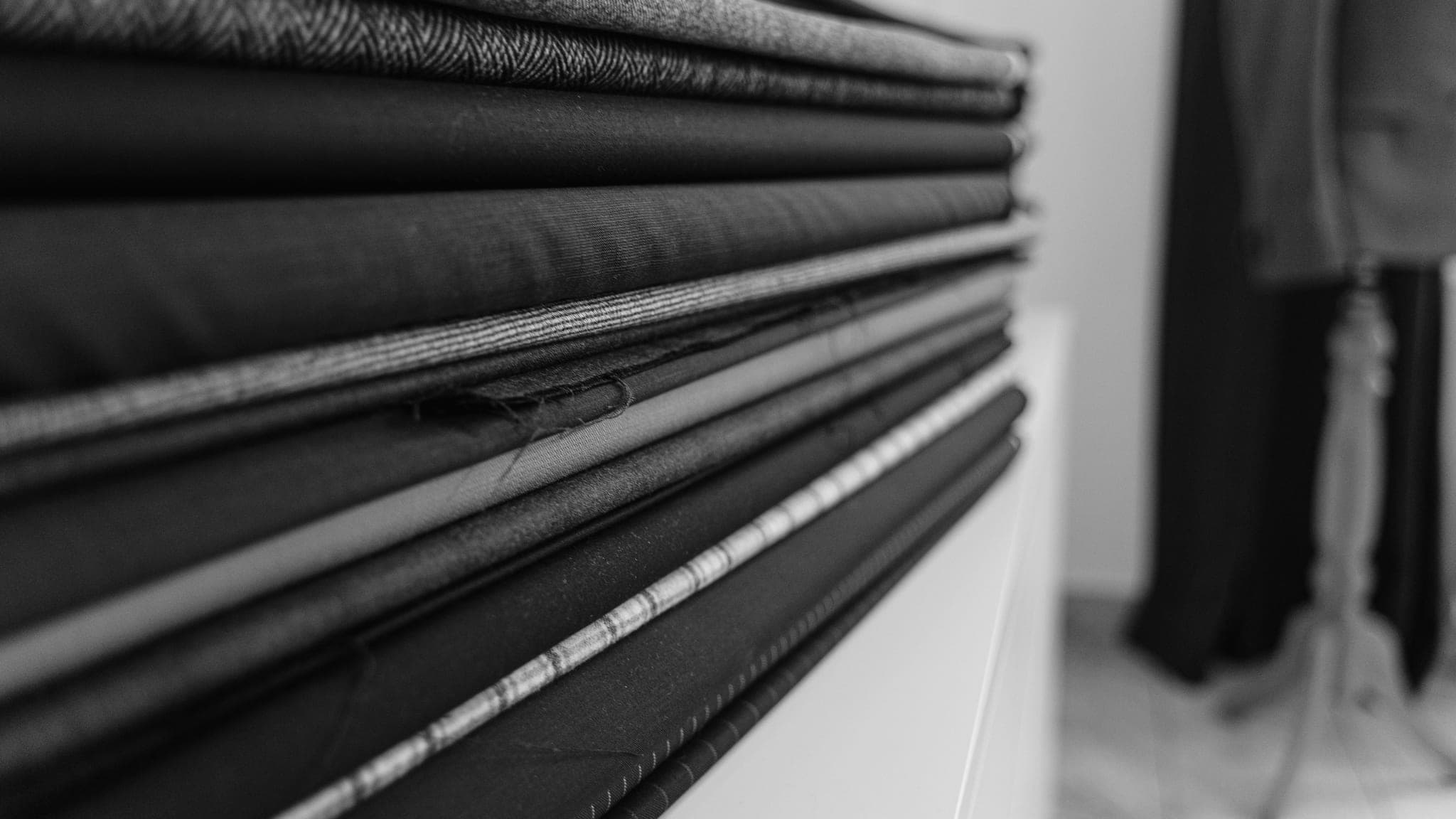 Stacked folds of cloth on a shelf, each layer a different material